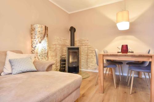 a living room with a bed and a table and a fireplace at Sonnenpark 01 in Korswandt