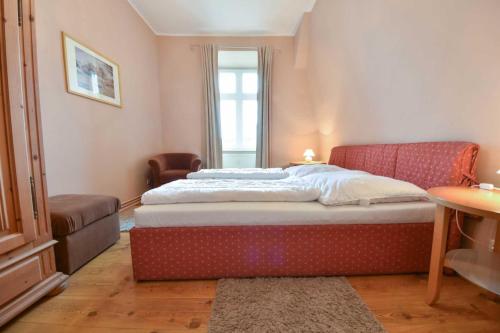 - une chambre avec un grand lit et une chaise dans l'établissement Villa Magdalena 06, à Ahlbeck