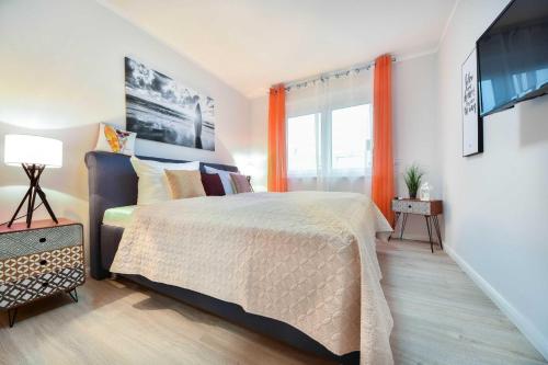 - une chambre avec un lit et une fenêtre avec des rideaux orange dans l'établissement Sonnenpark 08, à Korswandt