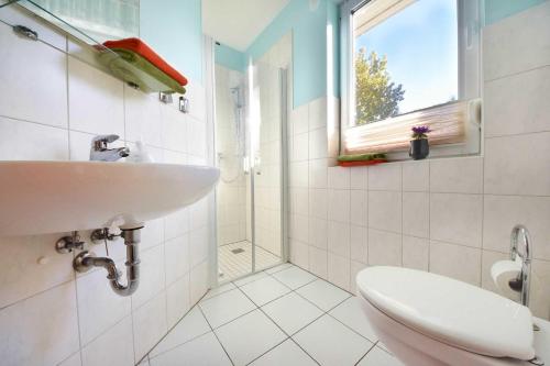 ヘリングスドルフにあるFerienhaus Thomasのバスルーム(洗面台、トイレ付)、窓が備わります。