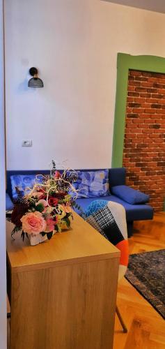 a living room with a couch and a table with flowers at Casa Crown in Braşov
