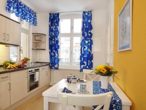 アールベックにあるVilla Luna Wohnung 10の青と白のカーテンとテーブル付きのキッチン