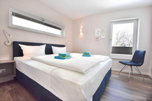 黑靈斯多夫的住宿－Haus Seven Seas - Wohnung Pazifik，一间卧室配有一张大床和蓝色椅子