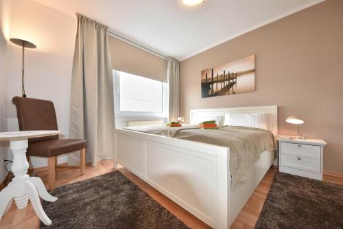 ヘリングスドルフにあるAppartement Duene 24のベッドルーム(白いベッド1台、デスク、椅子付)