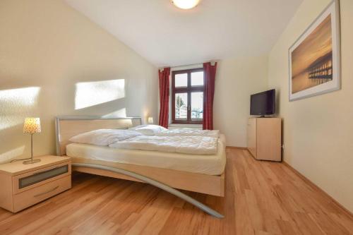 ヘリングスドルフにあるVilla Lamora 01のベッドルーム(ベッド1台、テレビ付)