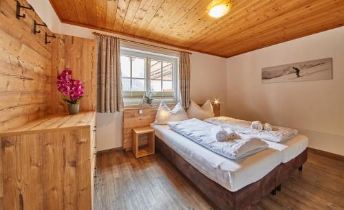 a bedroom with a bed in a room with a window at Delfi Ski & Bike Appartements in Saalbach-Hinterglemm