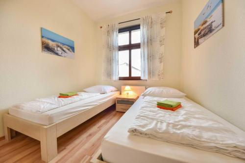 2 aparte bedden in een kamer met een raam bij Villa Lamora 03 in Heringsdorf