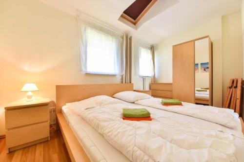 ヘリングスドルフにあるHaus Lamora 08のベッドルーム1室(白い大型ベッド1台、緑の枕2つ付)
