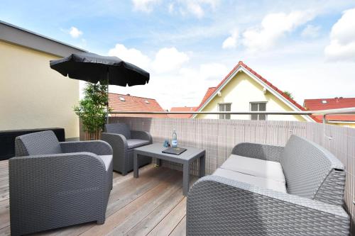 un patio con sedie e ombrellone su un balcone di Sonnenpark 15 a Korswandt