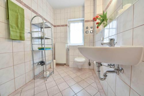ein Bad mit einem Waschbecken und einem WC in der Unterkunft Haus am Schloonsee 03 in Bansin
