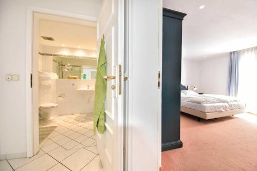 ヘリングスドルフにあるVilla Hohe Düne 01のベッドルーム1室(ベッド1台付)、バスルーム(バスタブ付)が備わります。