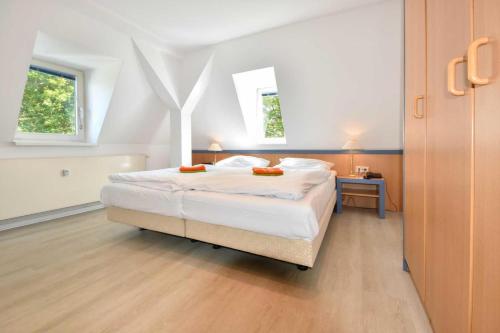 ヘリングスドルフにあるVilla Hohe Düne 08のベッドルーム1室(白いシーツ付きのベッド1台、窓2つ付)