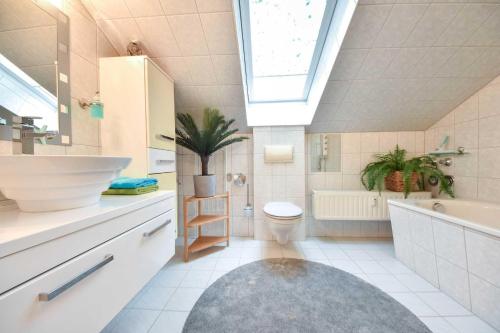 La salle de bains est pourvue d'un lavabo, de toilettes et d'une baignoire. dans l'établissement Villa zur See - FeWo 08, à Heringsdorf