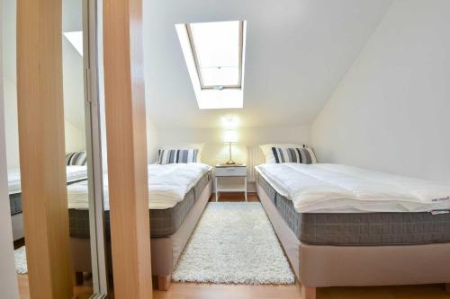 - 2 lits dans une petite chambre avec fenêtre dans l'établissement Villa zur See - FeWo 08, à Heringsdorf