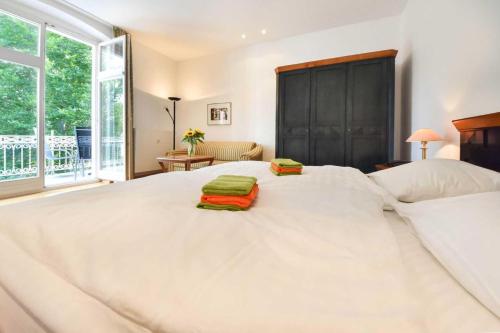 ヘリングスドルフにあるVilla Hohe Düne 06の白い大型ベッド(緑のタオル2枚付)