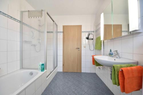ein weißes Badezimmer mit Badewanne und Waschbecken in der Unterkunft Ferienwohnung Elunia in Heringsdorf