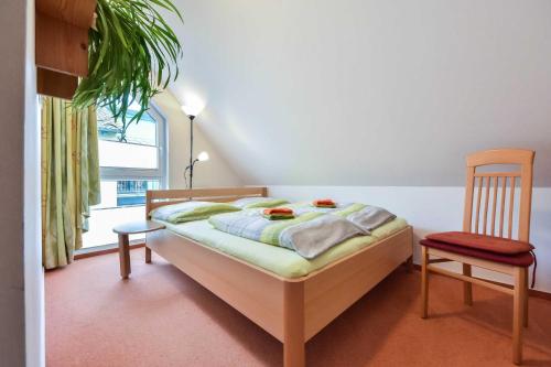 ein Schlafzimmer mit einem Bett und einem Stuhl und einem Fenster in der Unterkunft Ferienwohnung Elunia in Heringsdorf