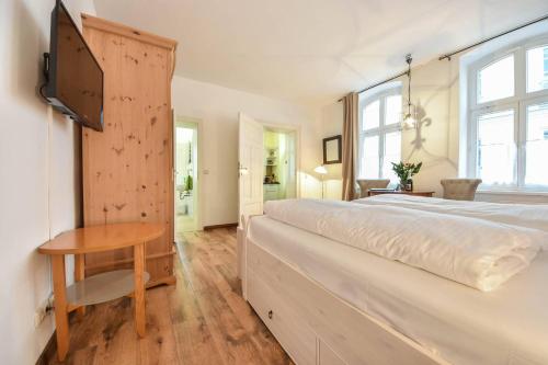 ein Schlafzimmer mit einem großen Bett und einem Holztisch in der Unterkunft Villa Magdalena 07 in Ahlbeck