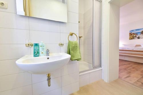 ein weißes Bad mit einem Waschbecken und einer Dusche in der Unterkunft Villa Magdalena 07 in Ahlbeck
