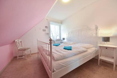 1 dormitorio blanco con 1 cama blanca y 1 silla en Ferienhaus Waldhaus, en Korswandt
