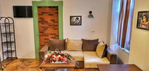 a living room with a couch and a brick wall at Casa Crown in Braşov