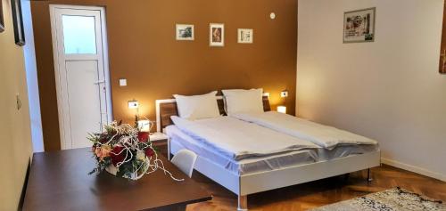 una camera da letto con un letto e un tavolo con fiori di Casa Crown a Braşov