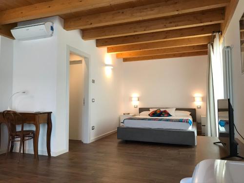 1 dormitorio con cama, mesa y escritorio en Carmen de Nella Eco Lodge 4*, en Caprino Veronese