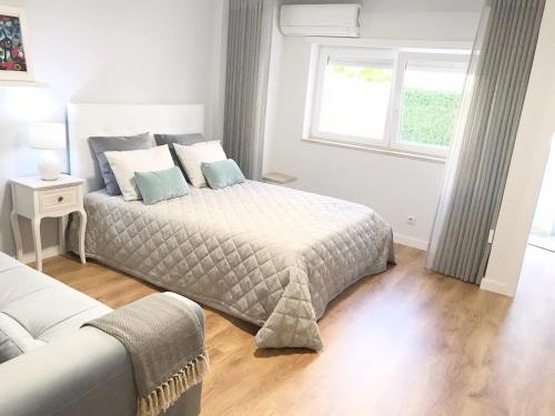 ein Schlafzimmer mit einem Bett, einem Fenster und einem Sofa in der Unterkunft Aveiro, Ria e Arte in Aveiro