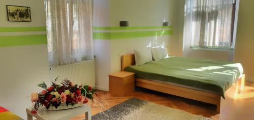 a bedroom with a green bed and a table with flowers at Casa Crown in Braşov