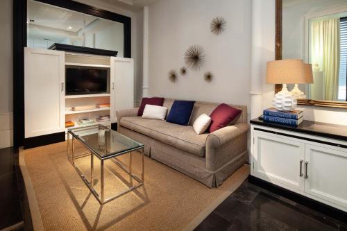 ein Wohnzimmer mit einem Sofa und einem Glastisch in der Unterkunft Elegante Apartamento Plaza Constitución in Málaga