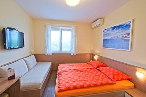 a small bedroom with a bed and a window at Guesthouse Opara in Piran