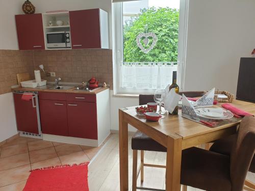 a kitchen with a wooden table and a kitchen with red cabinets at Marumparkblick 2 modern in Bad Sobernheim