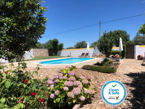 a swimming pool in a yard with flowers and a sign at A Flor Da Rosa in Crato