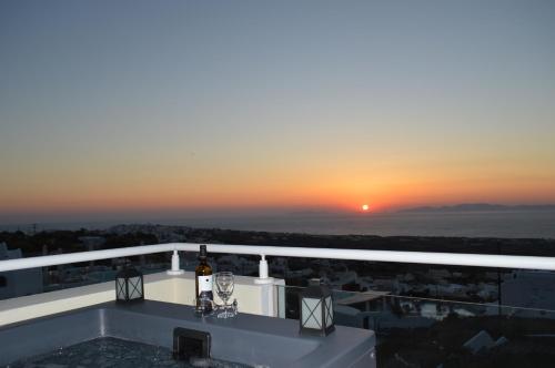 a view of the sunset from the balcony of a building at Kiklamino Sunset Studios in Oia