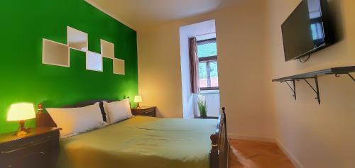 a green bedroom with a bed with a green wall at Casa Crown in Braşov