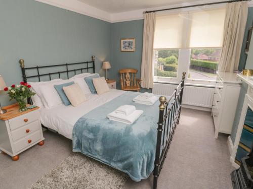 Un dormitorio con una cama grande y una ventana. en Arden House, en Whitby