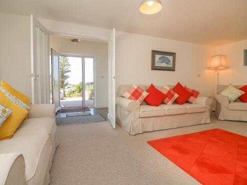 a living room with two white couches and a red rug at Tidewood in Bideford