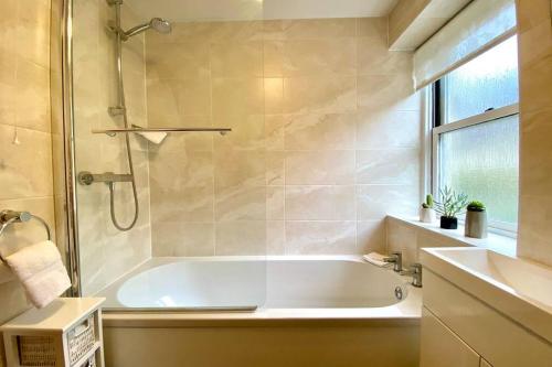 a bathroom with a bath tub and a sink at Apple Cottage - Central Frome - Outdoor Space in Frome