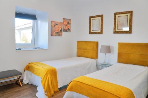 a bedroom with two beds and a window at Sleep In Bucelas in Bucelas