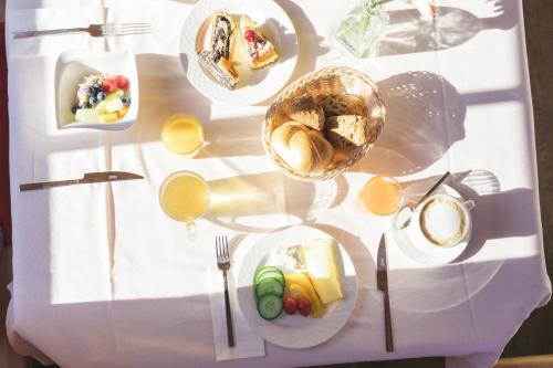 a white table with plates of food on it at Feelfree Nature Resort in Oetz