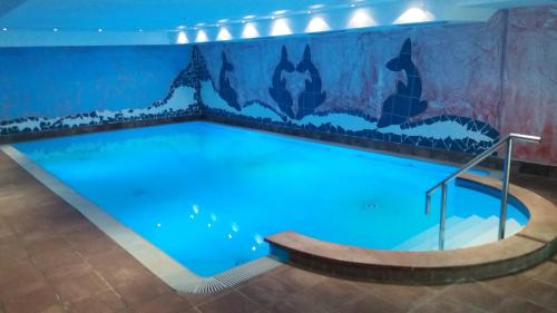 uma grande piscina com uma pintura na parede em Land-gut-Hotel Zum alten Forsthaus - Aufladestation für Elektroautos em Hürtgenwald