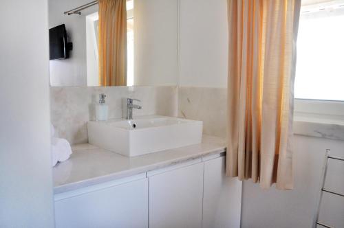 a bathroom with a white sink and a mirror at Sleep In Bucelas in Bucelas