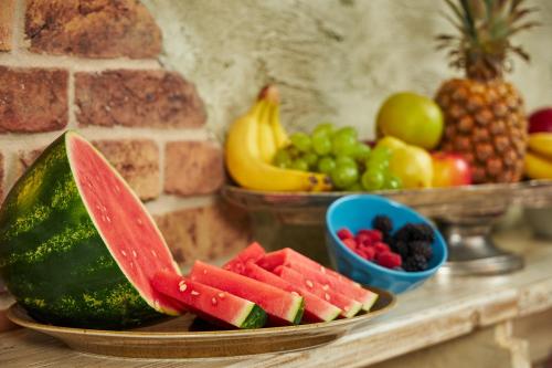 a plate of watermelon and fruit on a counter at Penzion BERG in Bratislava