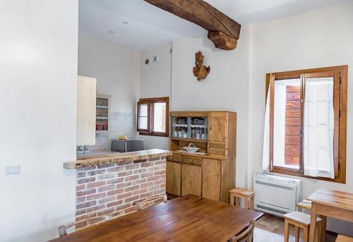 uma cozinha com uma lareira de tijolos e uma mesa de madeira em Casa Dal Zotto em Volpago del Montello