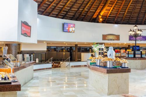 a lobby of a hotel with a counter with food at Crown Paradise Club Cancun - All Inclusive in Cancún