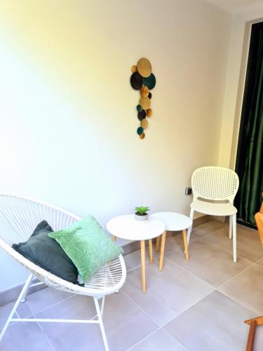 a living room with two chairs and a table at Appartement le Cattleya à proximité du lagon de l'Ermitage les bains in Filaos
