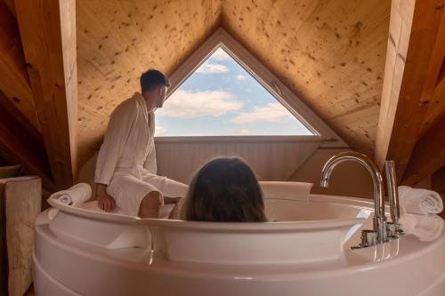 Ein Mann und eine Frau sitzen in einer Badewanne im Badezimmer. in der Unterkunft Villa del Poggio Prosecco Bike Hotel in San Pietro di Feletto