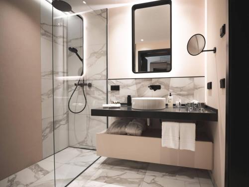 ein Bad mit einer Dusche, einem Waschbecken und einem Spiegel in der Unterkunft Romantik Hotel FreiWerk in Stolberg i. Harz