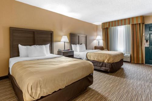 A bed or beds in a room at Quality Inn & Suites Hanes Mall