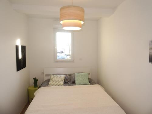 1 dormitorio con cama y ventana en Appartement neuf 6 couchages 50 metres de la plage, en Gruissan